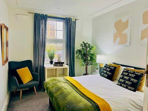 um quarto com uma cama, uma cadeira e uma janela em Meadows Court -Wyndale- Central Mansion Style 3BR em Birmingham
