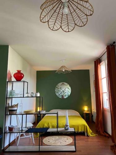 - une chambre avec un lit jaune et un mur vert dans l'établissement Studio proche Disneyland Paris, à Magny-le-Hongre