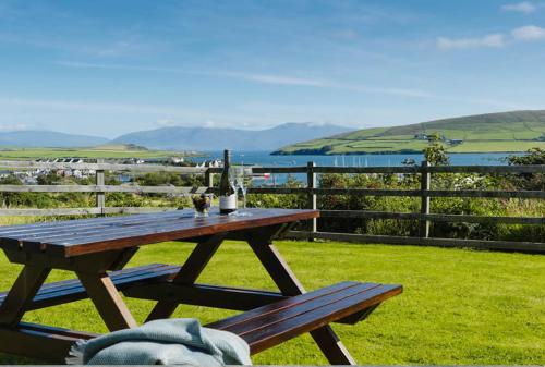 a wooden picnic table with a view of the ocean at 18 Ard na Mara in Dingle