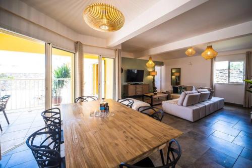 a living room with a wooden table and chairs at La belle Villa Jolicoeur & sa piscine chauffée in Saint-Pierre