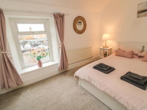 a bedroom with a bed and a window at Cosy Cottage in Morpeth