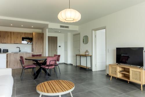 un salon avec une table et des chaises et une cuisine dans l'établissement Flaubert 16 - Domaine d'Arca - 4 pers - étage 1, à Porto-Vecchio