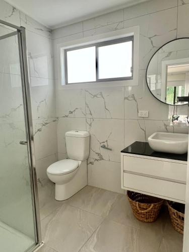 a bathroom with a toilet and a sink and a mirror at Rye's Get Away in Rye