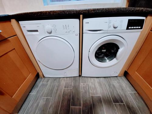 a washing machine and a washer and dryer in a kitchen at Burns Street - Stay Sleep Rest in Nottingham