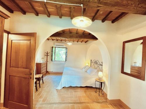 een slaapkamer met een bed en een gewelfde deur bij Castel Brunello in Montalcino
