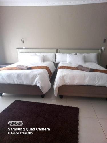 two beds sitting next to each other in a bedroom at ZWIZWO Guest House in Thohoyandou