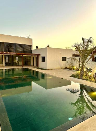a house with a swimming pool in front of a building at Serena Village Tulear in Toliara