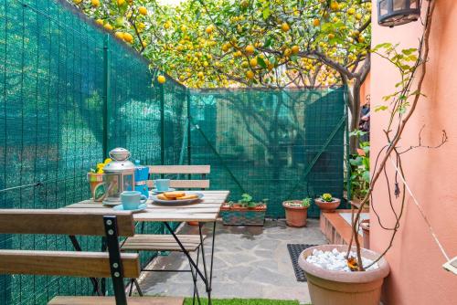 Un patio con una mesa y un naranjo en RivieraRent Bettina Holiday, en Finale Ligure