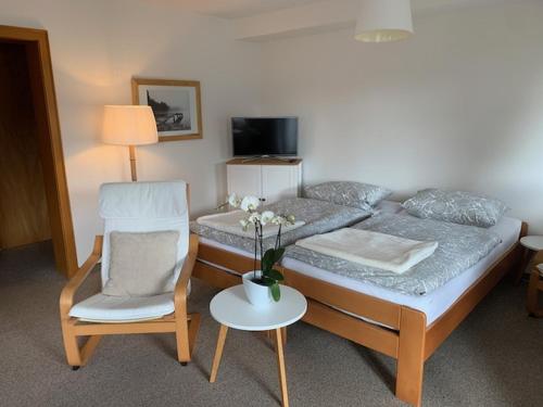ヒンターツァルテンにあるFerienhaus Rotzingerのベッドルーム1室(ベッド1台、椅子、花瓶付)