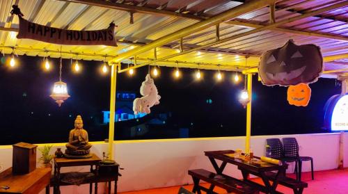 a room with tables and a happy holidays sign on the wall at Frozen Monks in Kodaikānāl