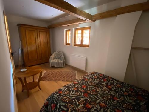 ein Schlafzimmer mit einem Bett, einem Tisch und einem Stuhl in der Unterkunft La ferme de Lili in Truchtersheim