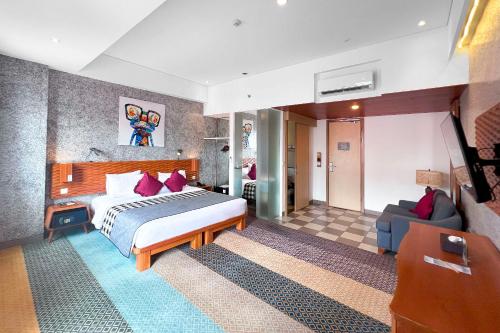 a hotel room with a bed and a couch at THE 1O1 Bandung Dago in Bandung