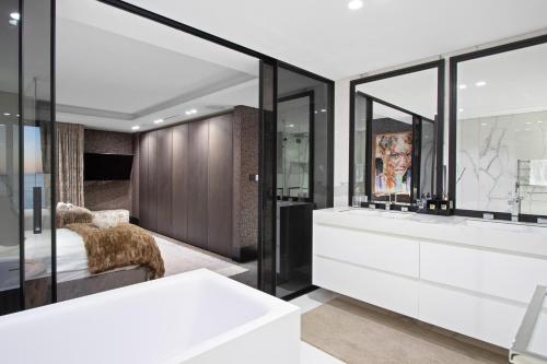 a bathroom with a white tub and glass walls at Aurum 501 in Cape Town