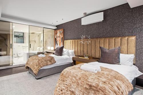 a bedroom with two beds and a bathroom at Aurum 501 in Cape Town