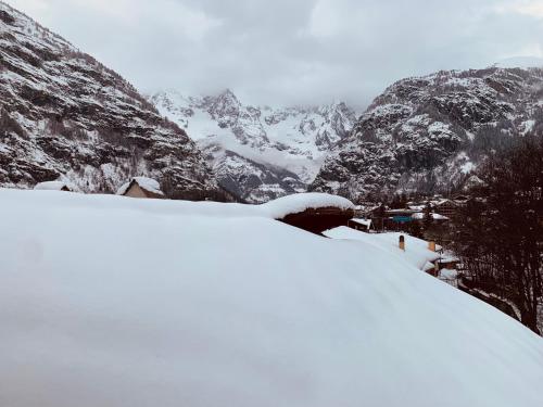 a snow covered mountain with a town in the distance at mansardacourmayeur in Courmayeur