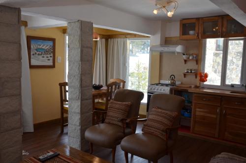 a kitchen with a table and some chairs and a counter at La Andyna Caviahue in Caviahue