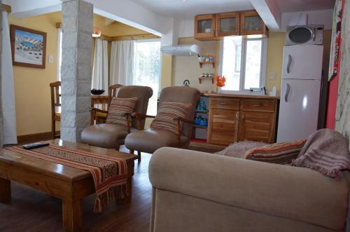 a living room with a couch and chairs and a kitchen at La Andyna Caviahue in Caviahue