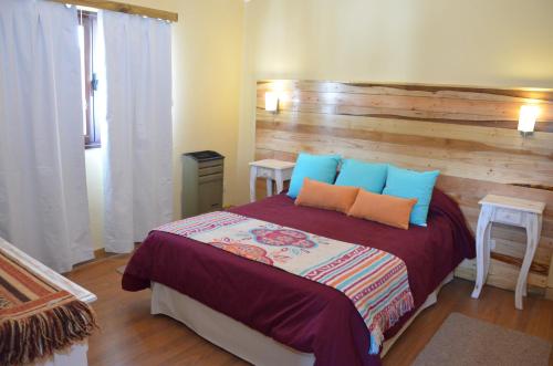 a bedroom with a bed with blue and orange pillows at La Andyna Caviahue in Caviahue