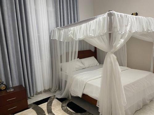 a bedroom with a bed with a canopy at Veron’s Elegant Home in Munyonyo
