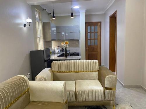 a living room with a couch and a kitchen at Veron’s Elegant Home in Munyonyo