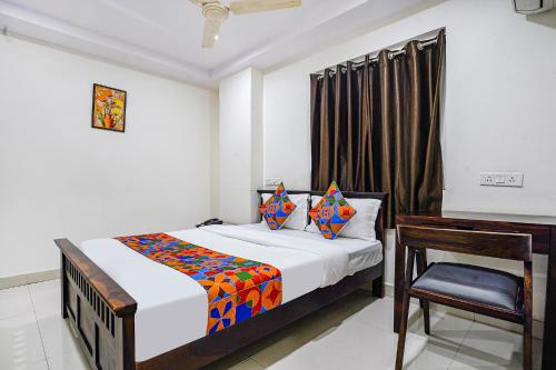 a bedroom with a bed and a desk in it at FabHotel Hamsa The Right Choice in Hyderabad