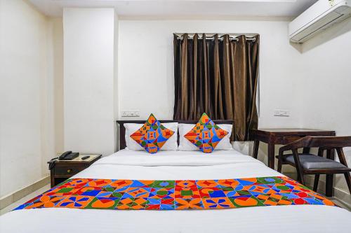 a bedroom with a bed with a colorful blanket on it at FabHotel Hamsa The Right Choice in Hyderabad