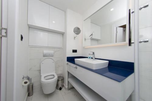 uma casa de banho branca com um WC e um lavatório em Panorama Sea View Orbi City Aparthotel em Batumi