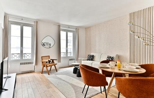 un salon avec un canapé et une table dans l'établissement Appartement Champ de Mars - Augereau, à Paris