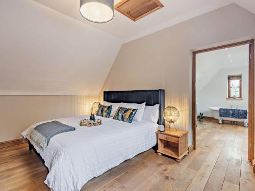 een slaapkamer met een groot bed en een grote spiegel bij 4 Bed in Lloc 92687 in Whitford