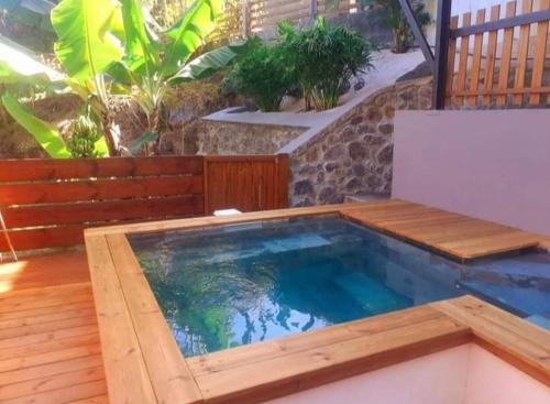 a swimming pool in a patio with a wooden deck at Le Monstera in Le Lambert