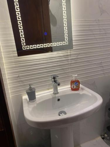 a white sink in a bathroom with a mirror at يقع المسكن في مدينة جدة الساحليه in Ḩayy al Ḩamdānīyah
