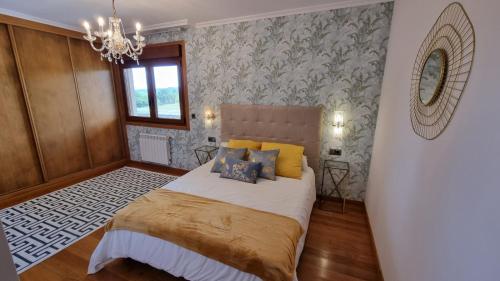 1 dormitorio con cama y lámpara de araña en casa de lujo con pisicina y jardin en el rural en Meis