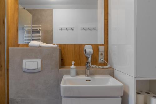a bathroom with a sink and a phone on the wall at Widok na Gondolę – Sun&Sport in Szczyrk