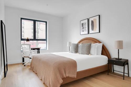a white bedroom with a large bed and a desk at Jersey City 3br w elevator roof gym nr path NYC-811 in Jersey City