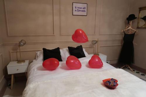 a bed with red balloons on top of it at Victorian Farrar Cottage in York