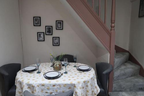 a table with a table cloth on it with wine glasses at Victorian Farrar Cottage in York