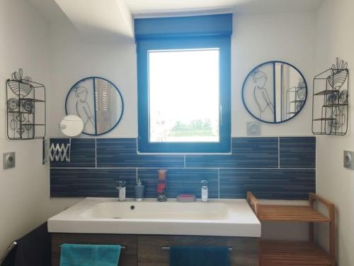 une salle de bain avec un lavabo blanc et une fenêtre dans l'établissement Maisonnette en campagne au calme, à Carpentras