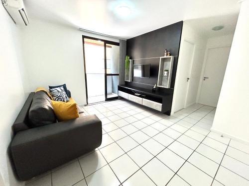 a living room with a couch and a microwave at Apartamento Beira Mar de Pajuçara / Maceió in Maceió
