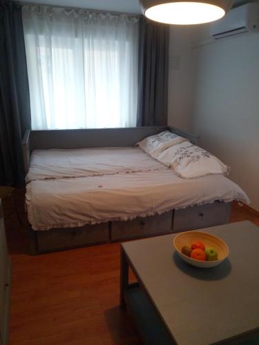 a bed in a room with a bowl of fruit on a table at VERICA in Samobor