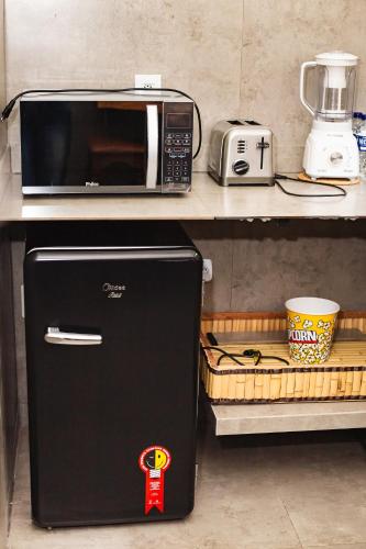 a microwave sitting on a counter next to a refrigerator at Quinta da Bocaina in Amparo