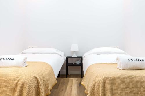 2 camas en una habitación con paredes blancas en Egona - Zi28 Centro de Zarautz, Reformada-Luminosa, en Zarautz