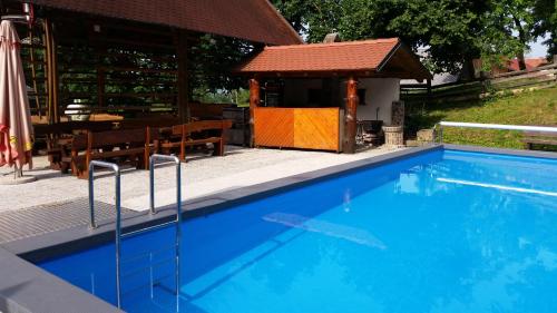 uma piscina azul com um gazebo em Turizem Pavlin Apartments em Šenturska Gora