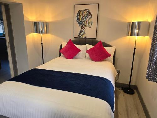 a bedroom with a large bed with red pillows at Heather House , luxury holiday house in Pitlochry in Pitlochry