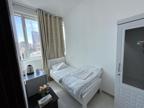a small room with a bed and a window at Corniche AD - Stunning Room in Abu Dhabi