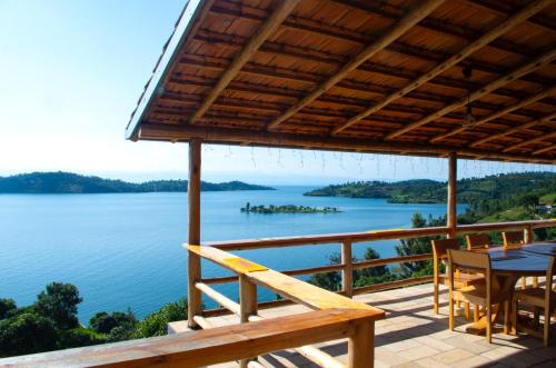 a deck with a table and chairs and a view of a lake at Umutuzo lodge Kivu lake 