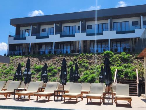 a row of chairs and umbrellas in front of a hotel at Serrano Exclusive in Tiradentes
