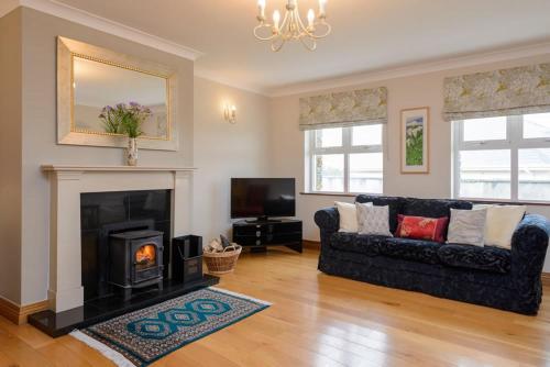 a living room with a black couch and a fireplace at House 23 Ard na Mara in Dingle