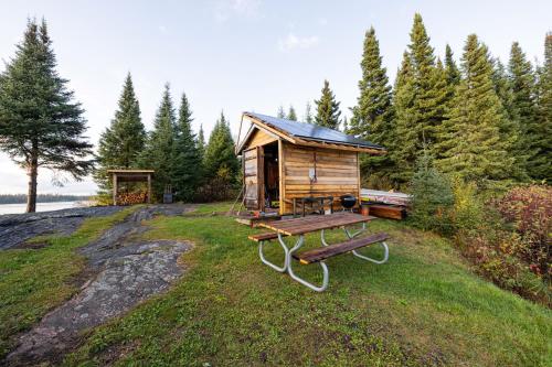 a wooden cabin on a hill with a picnic table at South McInnes in Red Lake