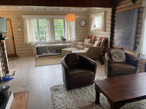 uma sala de estar com cadeiras, um sofá e uma mesa em Koselig familiehytte ved Bardola em Geilo
