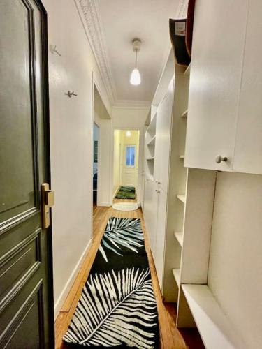 - un couloir avec un tapis zébraèbre au sol dans l'établissement Beau 3P en plein cœur du 15eme Proche de Beaugrenelle et de la Tour Eiffel. ., à Paris